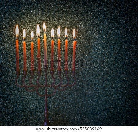 Menorah is a major traditional Jewish symbol for Hanukkah holiday. Low key image wasslightly toned for inspiration of vintage style and festive mood in the evening