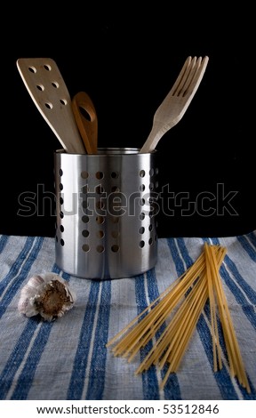 Three kitchen utensils made of wood in a metallic container