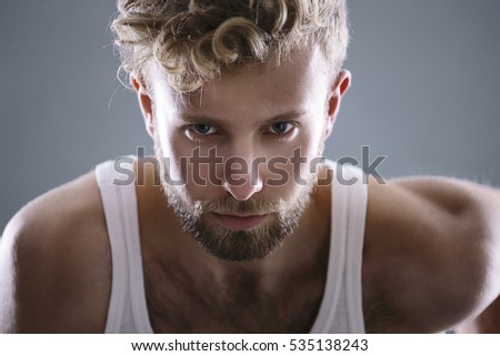 Close up man portrait. Young blond man wearing A-shirt looking to the camera
