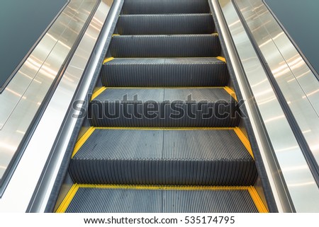 Escalator or moving staircase. Consist of step, handrail. Powered by electric motor for carry people between floor of indoor building i.e. shopping mall, airport, underground, office, metro and subway