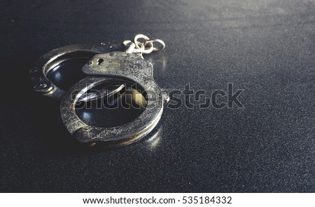 police handcuffs on a dark background with copy space, over light [blur and select focus background]