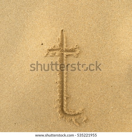 Handwriting words "t" on sand of beach
