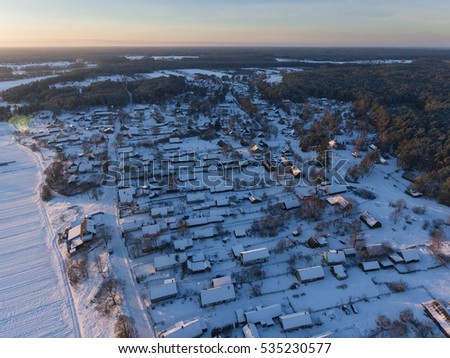 Aerial view of snowy village called Svendubre, near Druskinninkai city, Lithuania. Winter season at sunset.