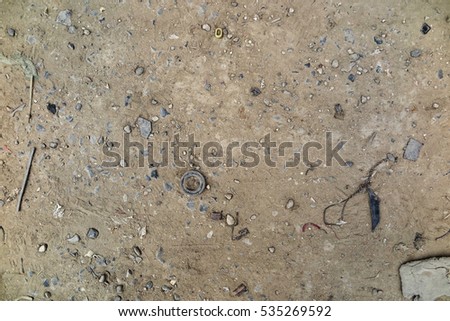 Used auto spare parts and household waste on the dirt dusty entrance at the car service