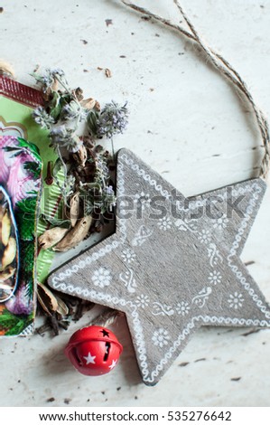 Wooden Christmas toy and spices on the table. Wooden star, dry mint, cardamom and cloves. Flat lay, top view, close up. Rustic Christmas background.