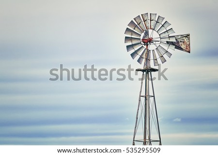 Vintage toned photo of an old western windmill tower, American wild west symbol, space for text.