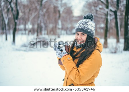 Stylish woman photographer with retro camera in winter park