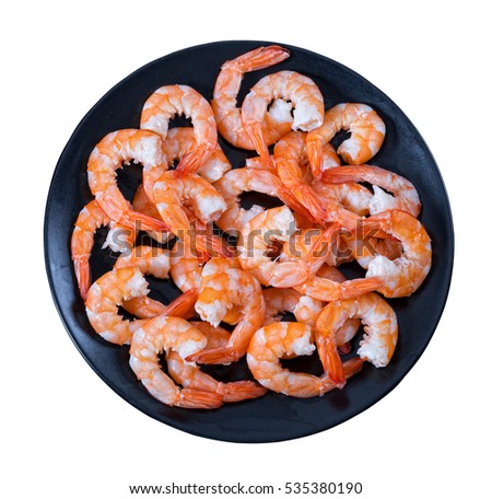 delicious boiled tails of king shrimps on black dish isolated on white background, view from above