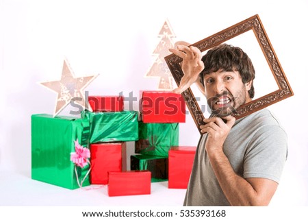 Portrait of a crazy man holding picture frame at christmas