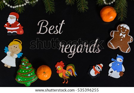 Xmas composition with text Best Regards on school blackboard and the Christmas decorations, toys (Santa Claus, Angel, a rooster, a snowman, a penguin) and tangerine