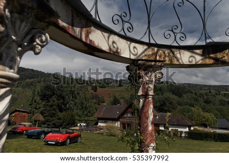view of the vintage sports cars through the arch element in top view