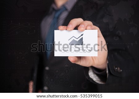 Businessman Holding White Visit Card With Icon And Text Success, Touch Screen. Virtual Icon. Graphs Interface. Business concept. Internet concept. Digital Interfaces