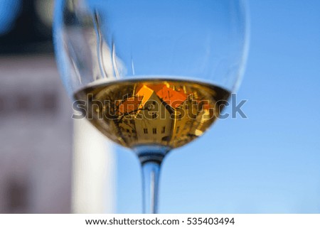 The glass of a white wine with old Tallinn view in a reflection
