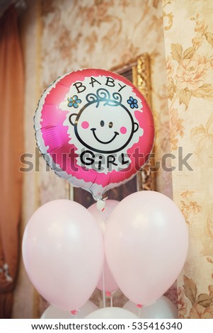 Balloon with lettering 'Baby-girl hangs on the top of balloons