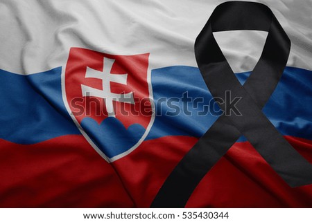 waving national flag of slovakia with black mourning ribbon