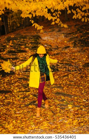 Happy girl in coat  with maple yellow leaves, autumn time