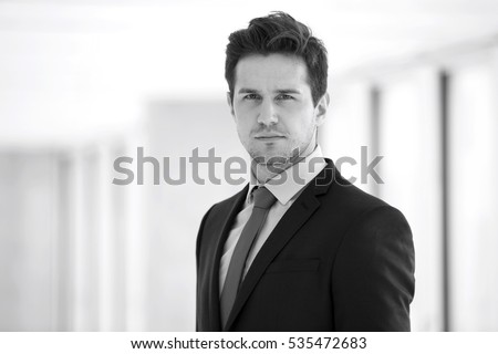 Portrait of confident young businessman wearing suit in office Royalty-Free Stock Photo #535472683