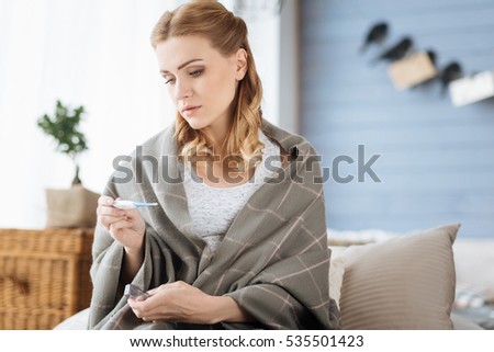 Pregnant woman looking at thermometer Royalty-Free Stock Photo #535501423