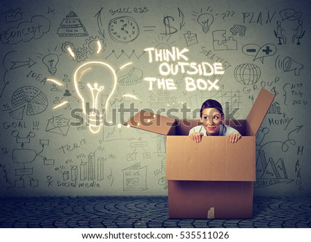 Young curious woman coming out of box isolated on gray info graphic wall background 
