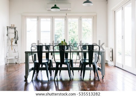 Gorgeous vintage styled light bright dining room with bifold doors Royalty-Free Stock Photo #535513282
