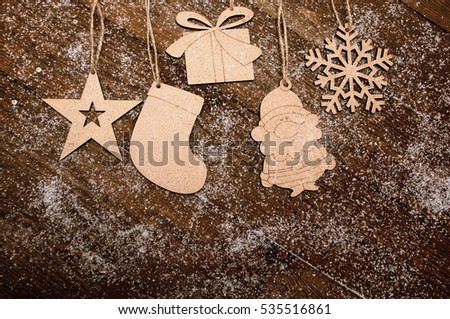 painted christmas natural wooden figures snowman, santa claus, mitten, starhanging on a wooden boards background