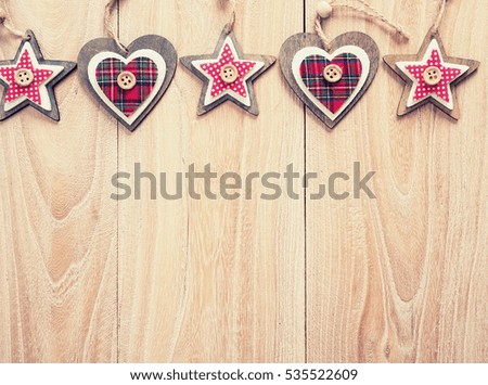 Christmas decoration red, white, gingham, stripes fabric stars and heart shape with buttons on rustic Elm wood background 