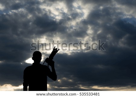 Silhouette Photographer holding a camera zoom range.