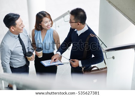 Vietnamese business people discussing financial report during the break Royalty-Free Stock Photo #535627381