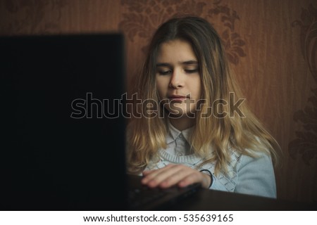 Teen girl excessively sitting at the computer laptop at home. he is a victim of online bullying Stalker social networks