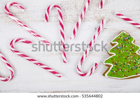 Gingerbread and candy canes on a wooden background. Christmas sweets and decorations