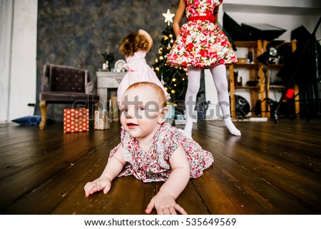 Family New year celebration. Girls having fun at the Christmas tree. To give gifts. Of celebration and fun.