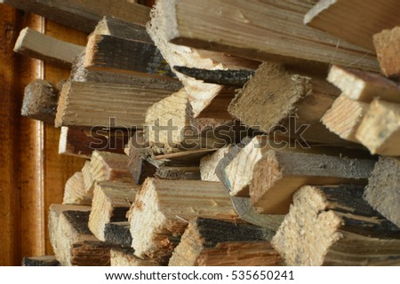 Dry old natural firewood background on a stack. Selective focus on a center of woodpile
