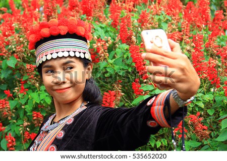 woman taking picture of herself in flower garden