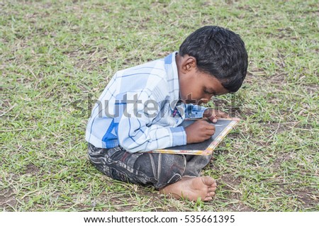 Portrait of a little rural school boy writing on slate