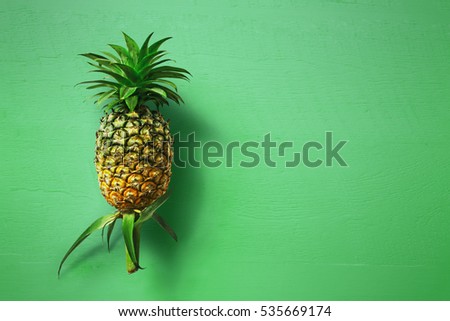 Place pineapple on green wood.