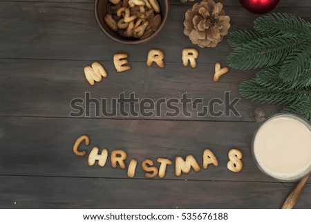 Merry Christmas word written with biscuit letters on wooden table. Christmas bakery background. Top view. Copy space.