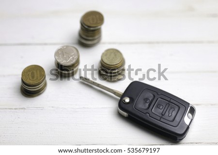car key and coin on background
