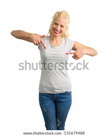 Woman in grey round neck T-shirt pointing at it with both hands 