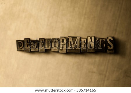 DEVELOPMENTS - close-up of grungy vintage typeset word on metal backdrop. Royalty free stock illustration.  Can be used for online banner ads and direct mail.