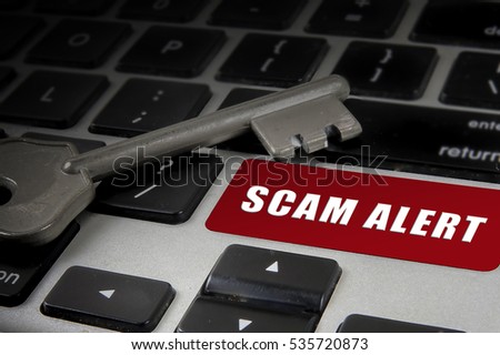 Scam alert word on the keyboard and key. IT security concept.