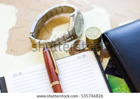 Money concept: Ã?Â�oins, purse, credit cards,wristwatch, pen, notebook. Background - map of the world.