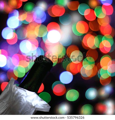 blurred bottle silhouette on background of colored lights and garlands of fireworks / enchanting the opening party