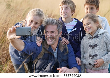 Man with kids in field taking selfie picture