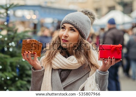 beautiful woman with two present boxes on new years and christmas decorations background