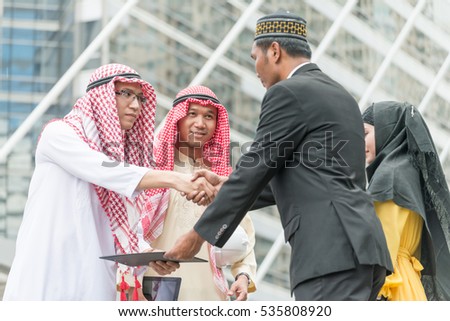 Business man from many country shake their hands after agreed an agreement outdoor in front of office building in business area. Business concept