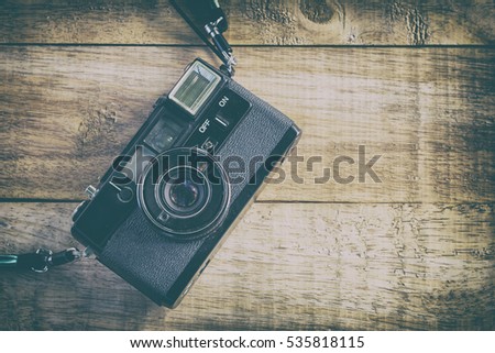 Old retro camera on wood table background