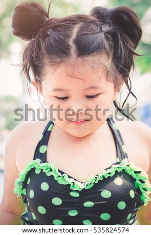 Vintage tone picture of cute little girl on swimming pool background , rest and relax concept