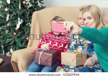 Happy family taking picture with smartphone on Chistmas decorations