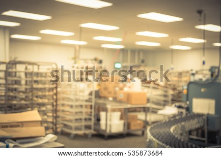 Blurred bakery shop in wholesale store with baking machine, oven, conveyor, production line, mixer and cooling plant. Modern food processing plant factory. Food industry backgroud. Vintage tone.
