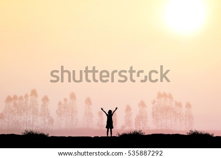Silhouette of freedom girl in sunrise background.